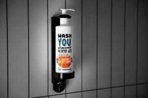 a bottle of wash you on a bathroom wall at You Hotels Deauville - Handwritten Collection in Deauville