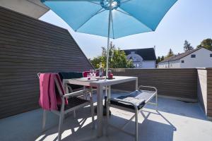 einen Tisch und Stühle mit Sonnenschirm auf einer Terrasse in der Unterkunft Boutique Apartments Kirchzarten in Kirchzarten