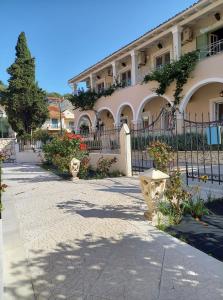 a building with a fence in front of it at Kalamionas Studios & Apartments in Kassiopi