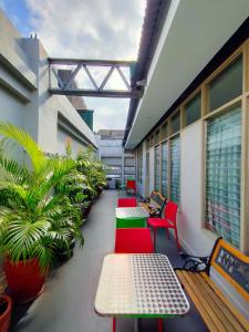 una fila de bancos y mesas en un edificio con plantas en 538 Dormitel, en Manila