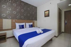Giường trong phòng chung tại Smarthomm Ancol Jakarta