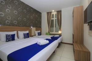 Giường trong phòng chung tại Smarthomm Ancol Jakarta