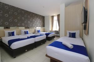 Giường trong phòng chung tại Smarthomm Ancol Jakarta