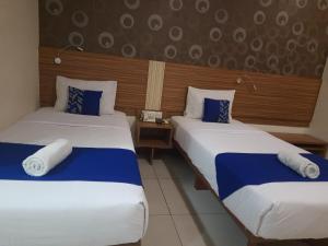 Giường trong phòng chung tại Smarthomm Ancol Jakarta
