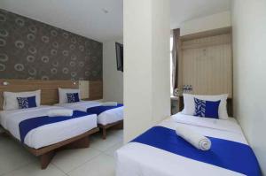Giường trong phòng chung tại Smarthomm Ancol Jakarta