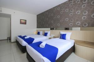 Giường trong phòng chung tại Smarthomm Ancol Jakarta