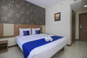 Giường trong phòng chung tại Smarthomm Ancol Jakarta