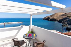 balcón con mesa, sillas y vistas al océano en Castello Apartments, en Panormos Rethymno