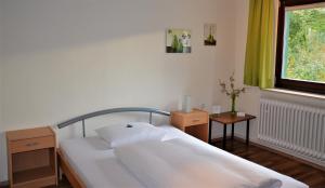 a bedroom with a bed and a window with green curtains at Hotel Landgasthof Wallburg in Eltmann