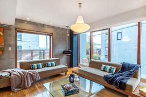 a living room with two couches and a large window at Asanagi by H2 Life in Niseko