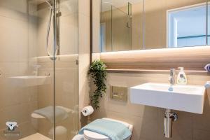 La salle de bains est pourvue d'un lavabo, de toilettes et d'un miroir. dans l'établissement KOZYGURU DOCKLANDS LUXURY WATER VIEW APT 1 BED VDO915, à Melbourne