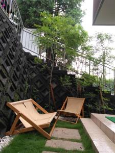two chairs sitting on the grass in a garden at guest house 鎌倉記憶 in Kamakura