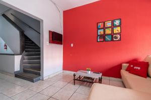 a living room with a red wall with a couch and a table at Hotel Mogi in Mogi das Cruzes