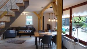 a living room with a staircase and a table and chairs at Forsthaus Timmerloher Weg in Schneverdingen
