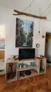 una sala de estar con una mesa y una pintura en la pared en BGMignonne, so cozy, so relaxing, so near center en Belgrado
