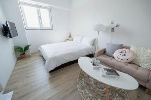 Camera bianca con letto e divano di June a Tainan