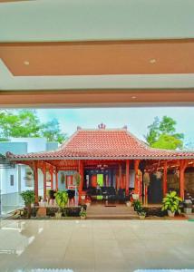 ein großes Haus mit einem roten Dach und einer Terrasse in der Unterkunft RedDoorz At Artomoro Guest House in Yogyakarta