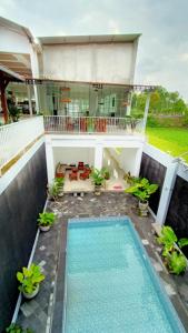 - une vue sur une maison avec une piscine dans l'établissement RedDoorz At Artomoro Guest House, à Yogyakarta