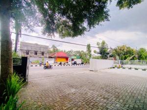 une personne voyageant en scooter dans un parking dans l'établissement RedDoorz At Artomoro Guest House, à Yogyakarta