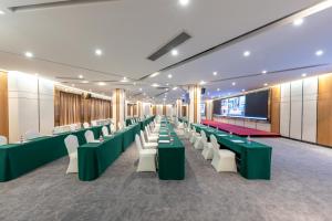 広州市にあるGHIC The Mulian Hotel of Bio-island Guangzhouの会議室(緑のテーブル、白い椅子付)