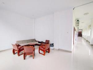 une chambre blanche avec une table et des chaises dans l'établissement RedDoorz At Artomoro Guest House, à Yogyakarta