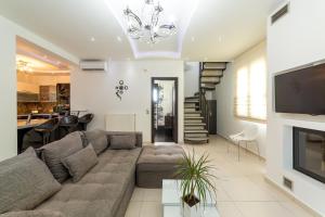 a living room with a couch and a tv at Villa Green Diamond - Private Heated Pool in Platanes