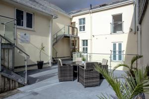 a patio with a table and chairs in front of a building at The Penthouse 15 At the Beach, Torcross in Beesands