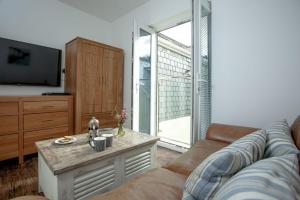 a living room with a couch and a tv at The Penthouse 15 At the Beach, Torcross in Beesands