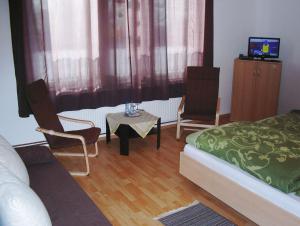 a bedroom with a bed and two chairs and a table at Hotel Landgasthof Puck in Böddenstedt