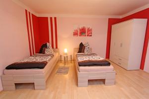 two twin beds in a room with red walls at Ferienwohnungen Greifswald_Wieck V in Wieck