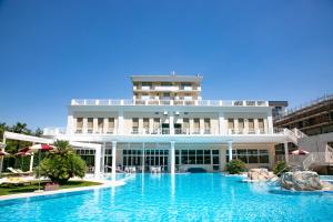 - un grand bâtiment avec une piscine en face dans l'établissement Hotel Terme All'Alba, à Abano Terme