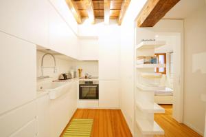 a kitchen with white cabinets and a wooden floor at DolceVita Apartments N. 479 in Venice