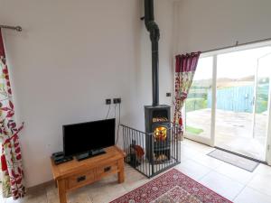 a living room with a fireplace and a tv at Mallard Cottage in Whitby