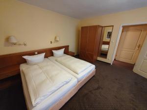 a bedroom with a large bed with white sheets at City Hotel Hanseatic Bremen in Bremen
