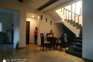 a woman sitting at a table in a room at Spandan bunglow in Alibaug