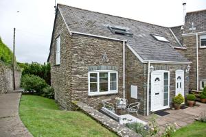 a brick house with a white door at Anchor Cottage, Strete, Dartmouth in Strete