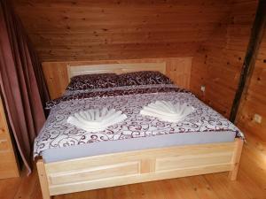 un letto in legno con due cuscini in una camera di legno di Apartman Miky a Drnholec