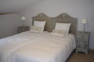 a bedroom with a white bed with two night stands at Le Clos des Oiseaux in Saintes