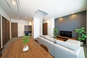 een woonkamer met een bank en een tafel bij STAY & GO Shinsaibashi-Kita in Osaka