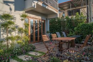 a wooden deck with a table and chairs in a garden at Nuan Boutique Hotel in Chiang Mai