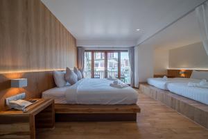 a large bedroom with two beds and a window at Nuan Boutique Hotel in Chiang Mai +34 photos