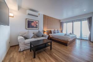 una sala de estar con 1 cama, 1 sofá y 1 cama y una habitación con en Nuan Boutique Hotel en Chiang Mai