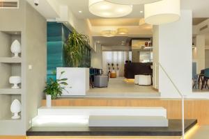 an office lobby with a white bench and plants at Albatros Beach Hotel in Letojanni