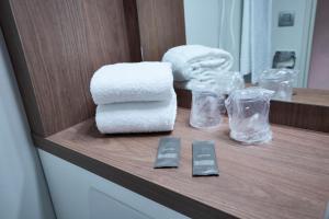 - un comptoir de salle de bains avec des serviettes et d'autres articles dans l'établissement Ampaline HOTEL - Perigueux Boulazac, à Boulazac