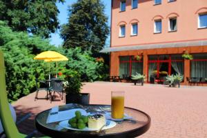 a table with a plate of food and a glass of orange juice at Salis Resort in Wieliczka