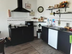 a kitchen with black counters and a sink and a clock at D'n Engel in Sittard +16 photos