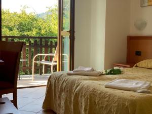 1 dormitorio con cama y vistas a un balcón en Casa Vacanze Orchidea en Pinerolo