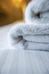 a stack of white towels sitting on a table at The Originals Access Hôtel Bordeaux Aéroport in Mérignac