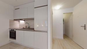 a kitchen with white cabinets and a sink at DA-DA Gallery Appart - Elegant Design Studio in Boudry in Boudry +11 photos