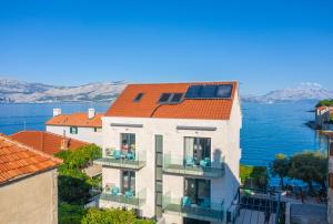 波斯蒂拉Villa Sanja的公寓大楼拥有橙色的屋顶和水面